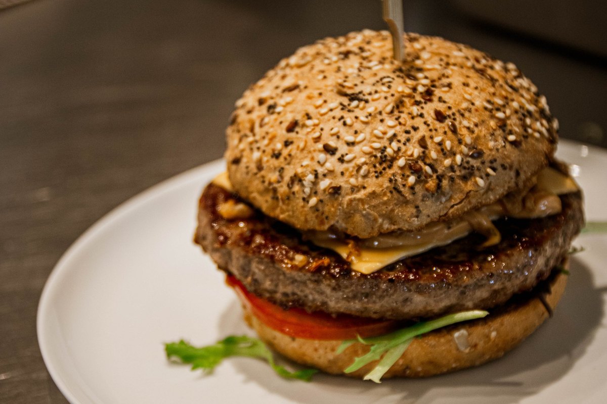 Burger met Iers rund, cheddar en gegrilde ui op een bord